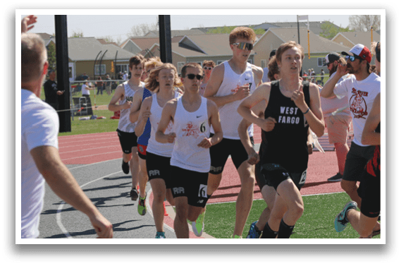 A group of people running on a track. Description generated by AI