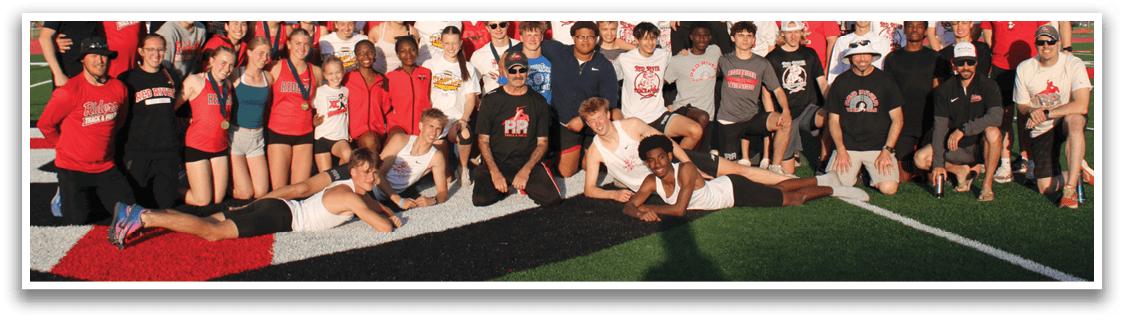 A group of people posing for a picture on a football field. Description generated by AI