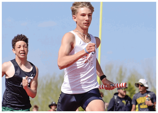 Two boys running on a track. Description generated by AI
