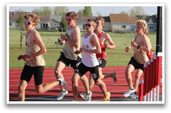 A group of runners wearing number tags on their shirts. Description generated by AI
