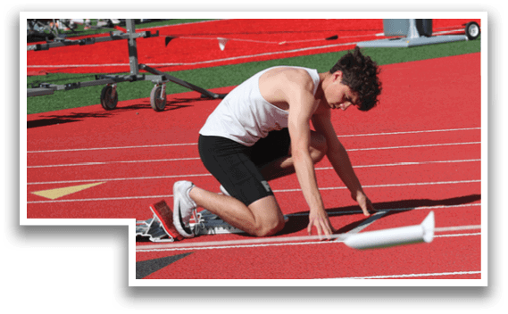 A man is bending over on a track. Description generated by AI