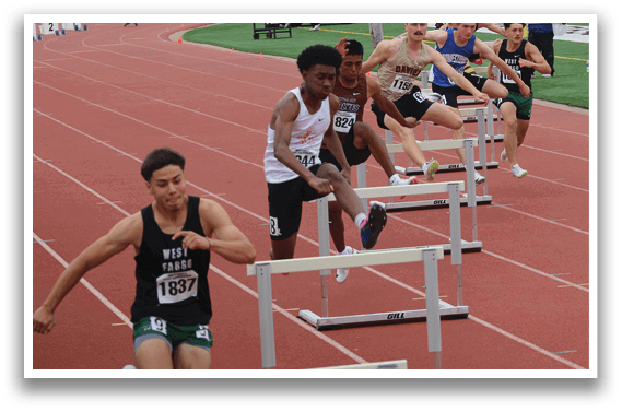 A man is running on a track with a barrier in front of him. Description generated by AI