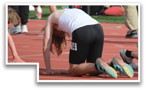 A runner is bent over on the track. Description generated by AI