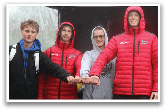 Four young men wearing red jackets and hoods. Description generated by AI