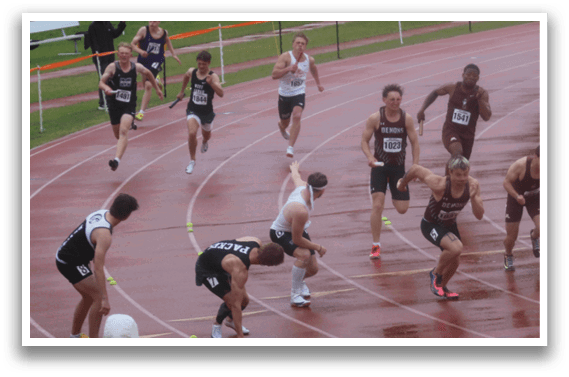 A group of people running on a track. Description generated by AI