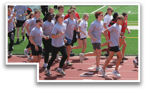 A group of people running on a track. Description generated by AI