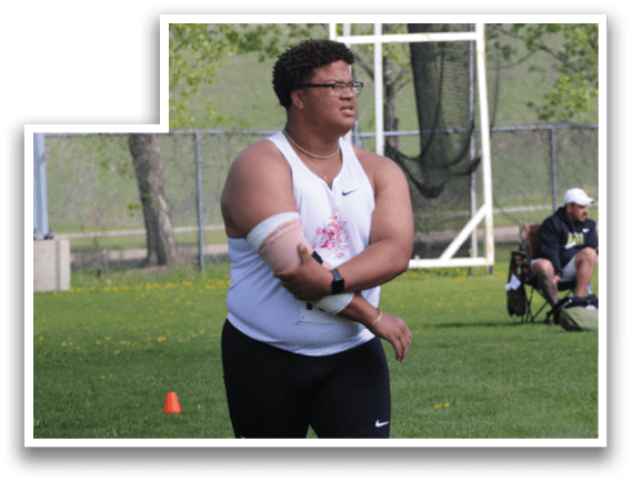A man in a white shirt and black shorts is holding a frisbee. Description generated by AI