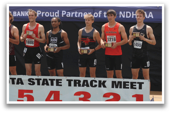 A group of men stand on a stage in front of a sign that says North Dakota State Track Meet. Description generated by AI