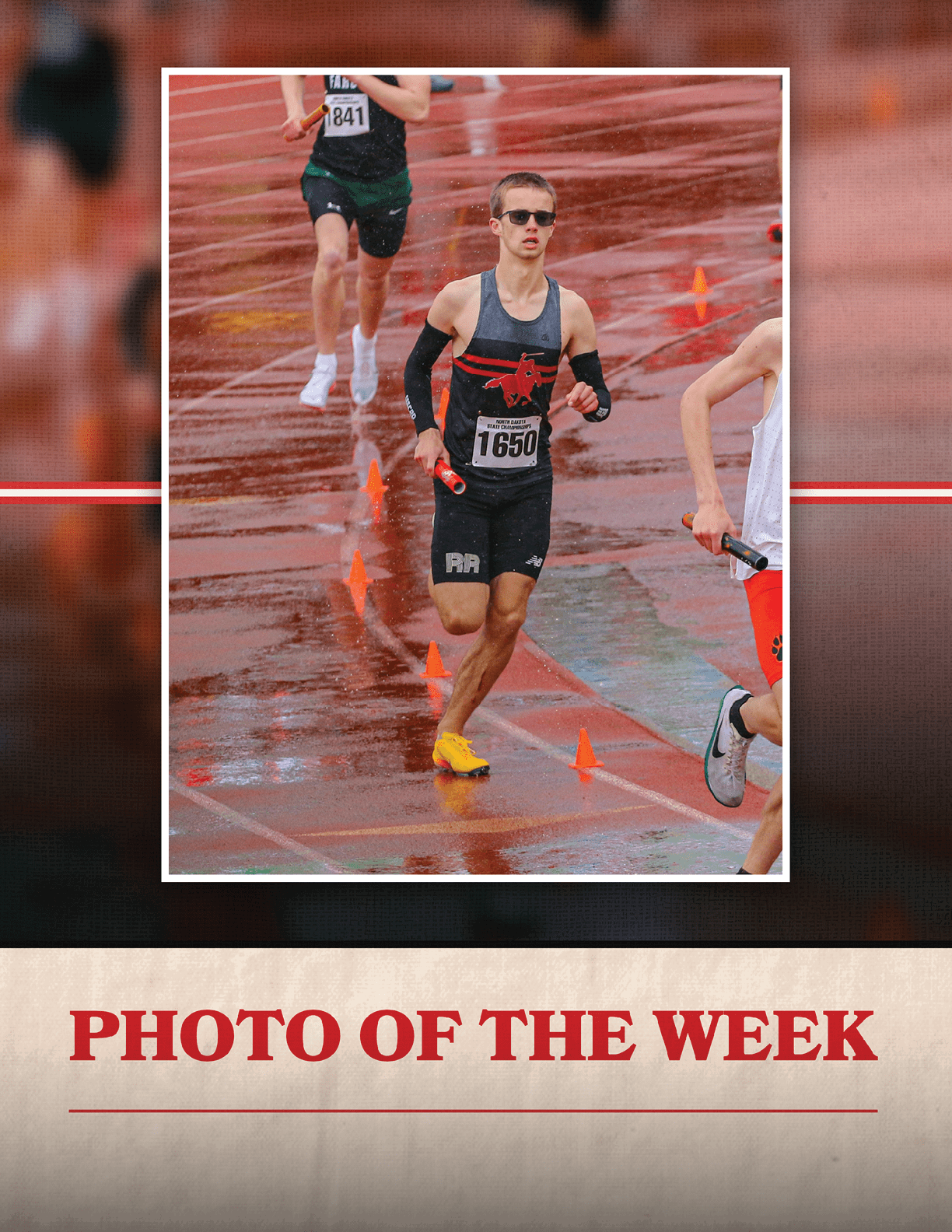 A runner in a black and red shirt running on a wet track. Description generated by AI