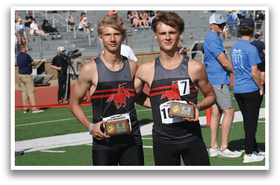 Two men holding trophies. Description generated by AI