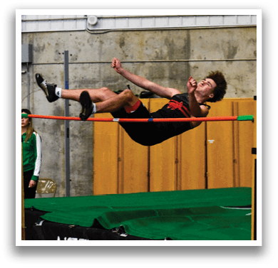 A man is jumping over a barrier in a gym, attempting to clear the obstacle. AI generated content
