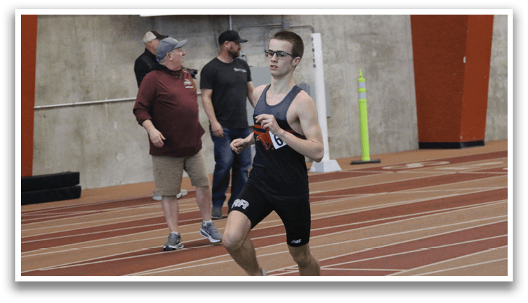 A man is running on a track, wearing a black shirt and shorts. AI generated content