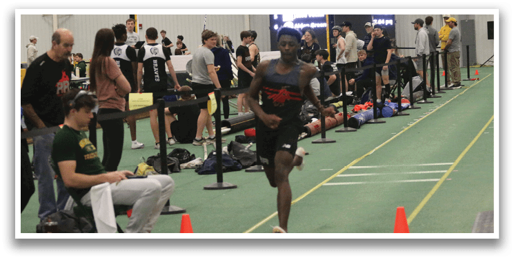 A man is running on a track with orange cones. Description generated by AI