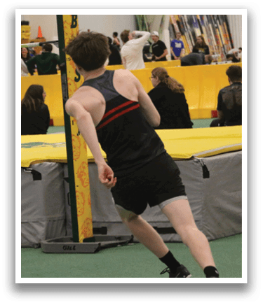 A man is running on a track with a yellow and black pole in front of him. Description generated by AI