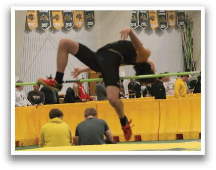 A man is jumping over a barrier. Description generated by AI