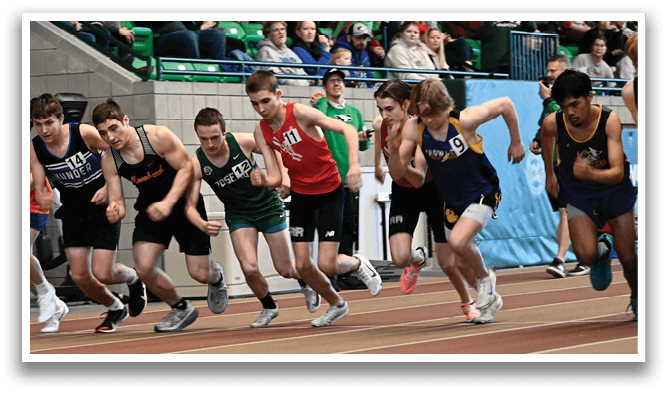 A group of young boys running on a track. Description generated by AI