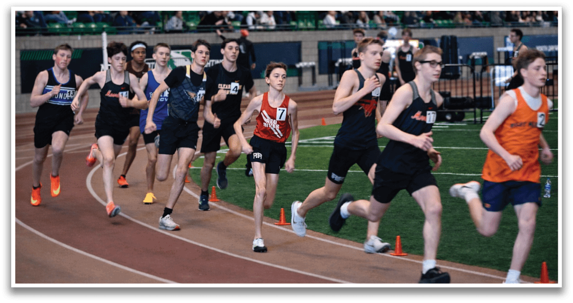 A group of young men running on a track. Description generated by AI