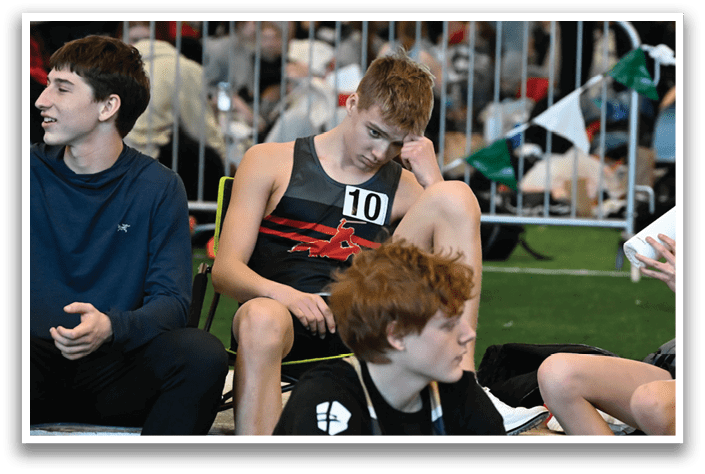 A group of young men sitting on a bench. Description generated by AI