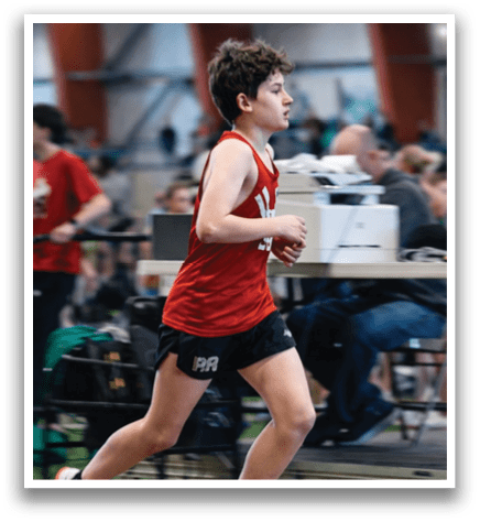 A boy running on a track. Description generated by AI