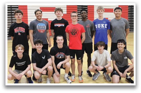 A group of young men in a gym pose for a picture. Description generated by AI