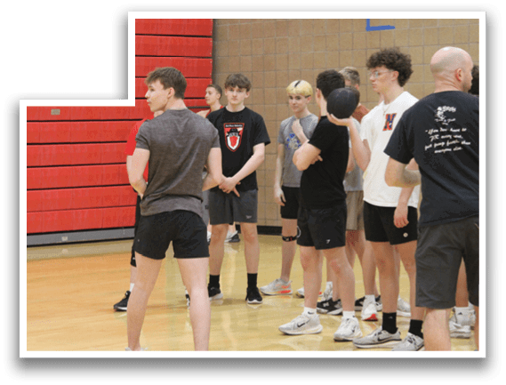 A group of young men are playing a game of basketball. Description generated by AI