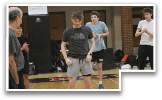 A group of people are standing on a basketball court. Description generated by AI