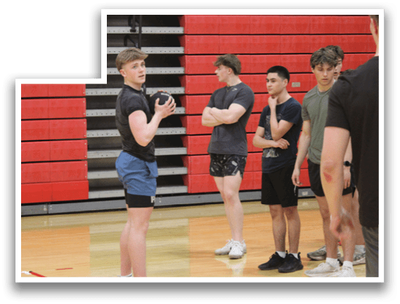 A group of people standing in a gym. Description generated by AI