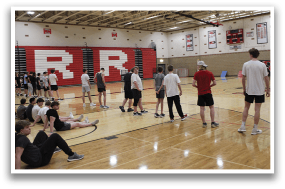 A group of people are standing in a gym. Description generated by AI