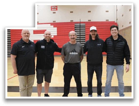 A group of men standing on a basketball court. Description generated by AI