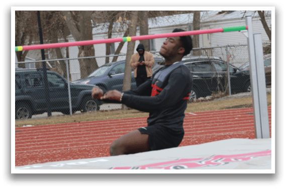 A man is jumping over a barrier. Description generated by AI