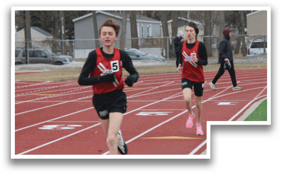 A boy running on a track with a red shirt. Description generated by AI