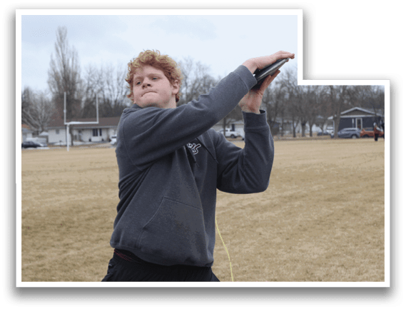 A man in a grey hoodie is swinging a baseball bat. Description generated by AI