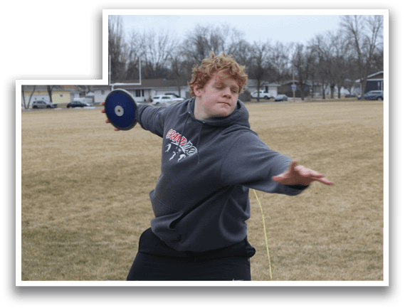 A man in a grey hoodie is throwing a frisbee. Description generated by AI