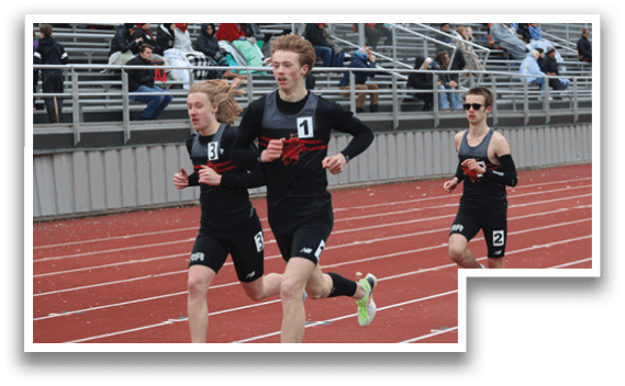 Three boys running on a track. Description generated by AI