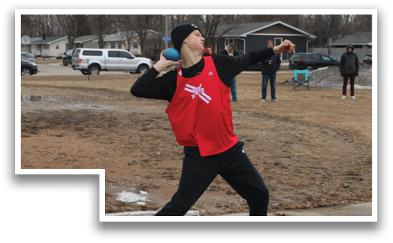 A man in a red shirt and black pants is throwing a frisbee. Description generated by AI