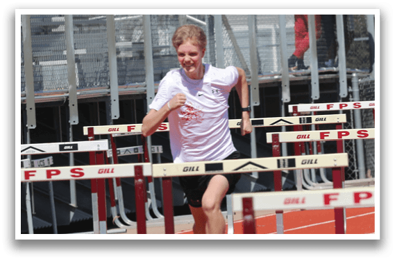 A man running on a track with a red and white shirt. Description generated by AI