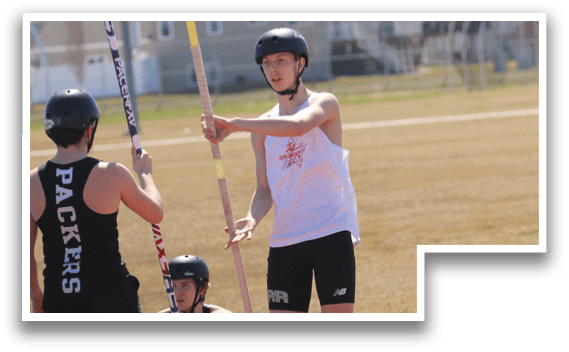Two men are holding poles and standing on a red surface. Description generated by AI