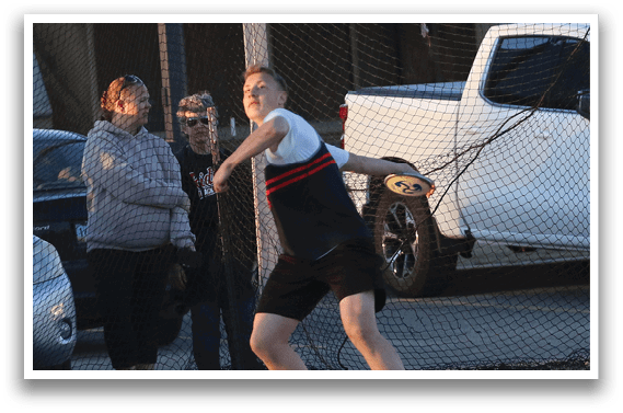 A man is throwing a frisbee in a parking lot. Description generated by AI