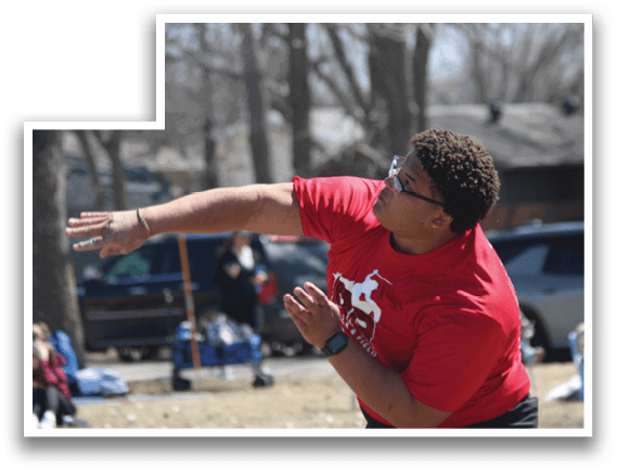 A man wearing a red shirt and glasses is throwing a frisbee. Description generated by AI