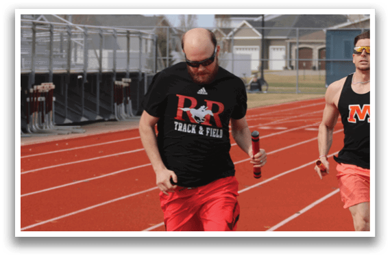 A man wearing a black shirt is running on a track. Description generated by AI