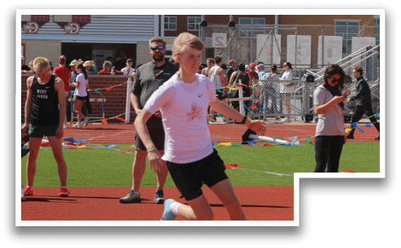 A boy running on a track. Description generated by AI