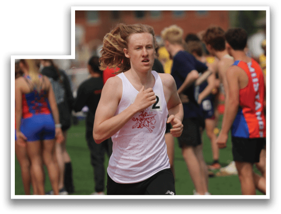 A man running on a track with a crowd of people behind him. Description generated by AI