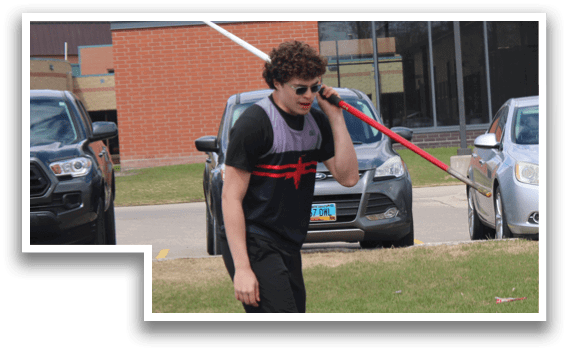 A boy is holding a red and black object. Description generated by AI