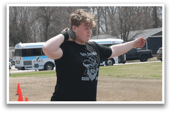 A man in a black shirt is holding a frisbee. Description generated by AI