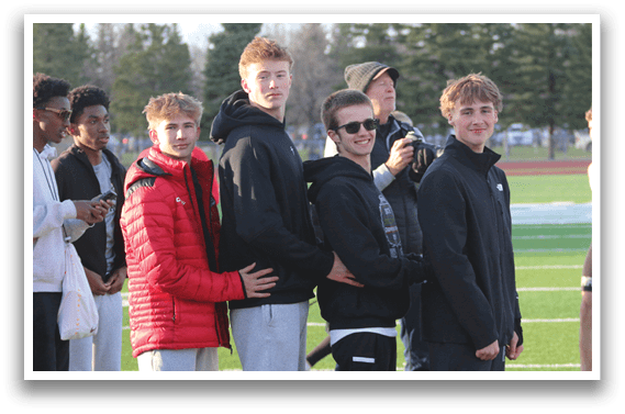 A group of young men standing on a field. Description generated by AI