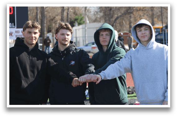 Four young men shaking hands. Description generated by AI