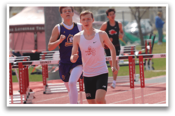 A group of young men running on a track. Description generated by AI