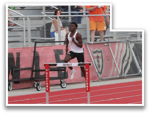 A track athlete is running on a track with a crowd watching. Description generated by AI