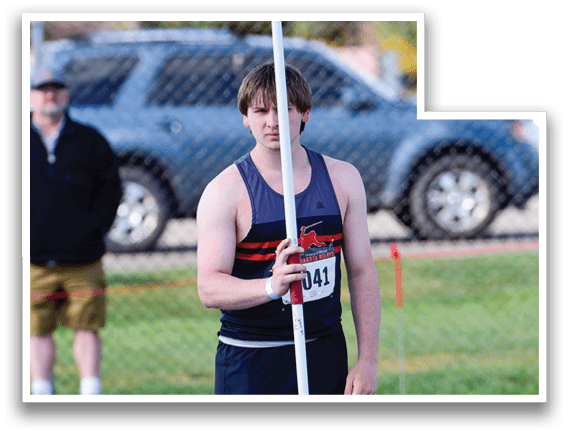 A man holding a pole in a field. Description generated by AI