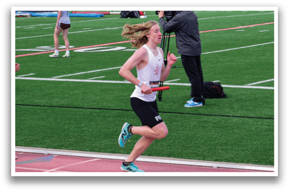 A man running on a track with a red and white shirt. Description generated by AI